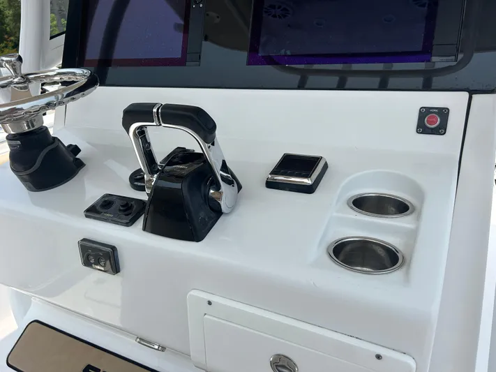  Yacht Photos Pics Control panel of 2018 Sportsman Open 312 Center Console boat with steering and cup holders.