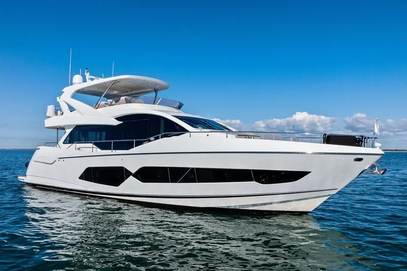 Tempus Fugit Yacht Photos Pics Luxurious 2019 Sunseeker 76 Yacht cruising on open water under clear blue skies.