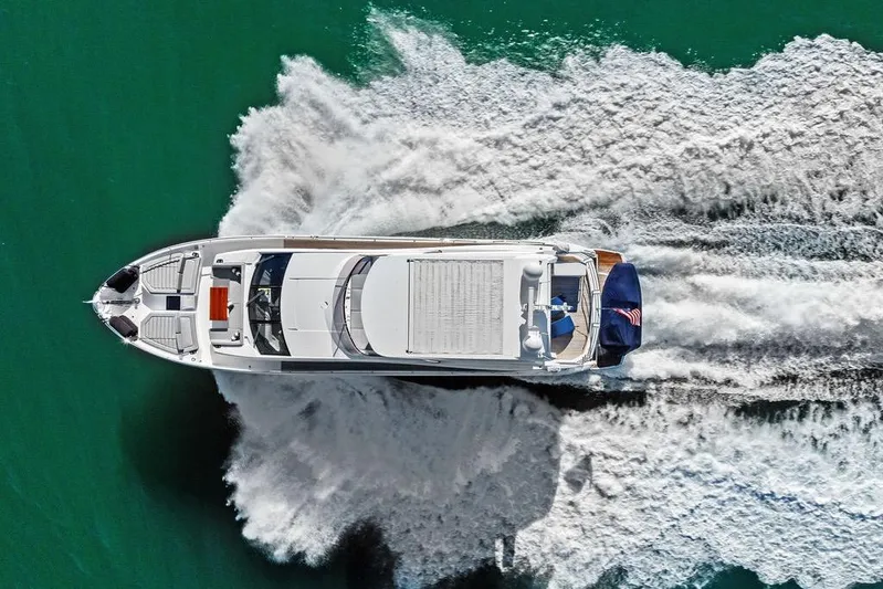 Tempus Fugit Yacht Photos Pics Aerial view of 2019 Sunseeker 76 Yacht cruising on turquoise water.