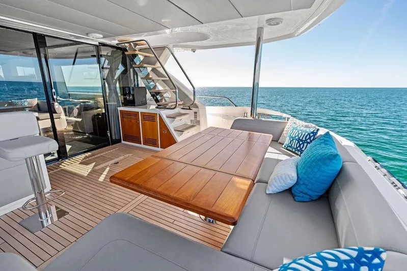 Tempus Fugit Yacht Photos Pics Luxurious 2019 Sunseeker 76 Yacht deck with ocean view, featuring elegant seating and wooden table.