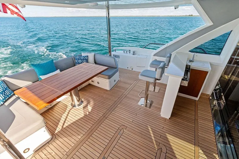 Tempus Fugit Yacht Photos Pics Luxurious 2019 Sunseeker 76 Yacht deck with seating, table, and ocean view.