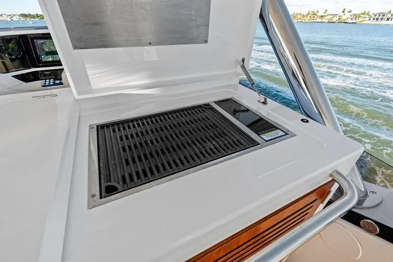 Tempus Fugit Yacht Photos Pics Outdoor grill on 2019 Sunseeker 76 Yacht, overlooking serene water view.