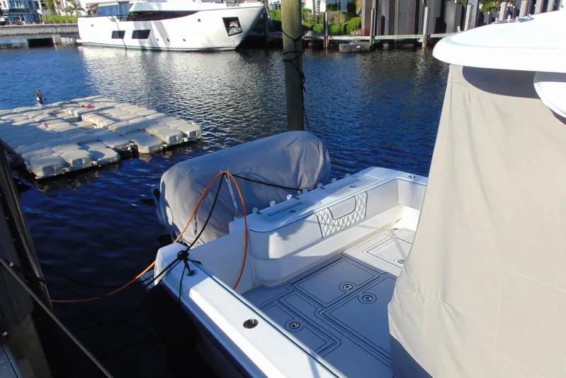 Atlas Yacht Photos Pics 2023 Contender 39 Fisharound docked, featuring spacious deck and covered outboard motor.