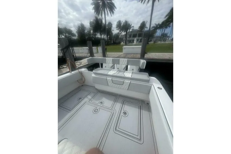 Atlas Yacht Photos Pics 2023 Contender 39 Fisharound boat interior with seating and deck, docked near palm trees.