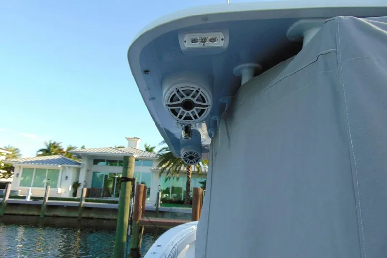 Atlas Yacht Photos Pics 2023 Contender 39 Fisharound boat with speakers, docked near waterfront homes.