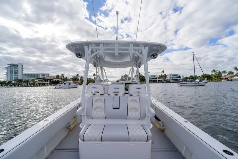 Atlas Yacht Photos Pics 2023 Contender 39 Fisharound boat on a calm waterway with cloudy sky.