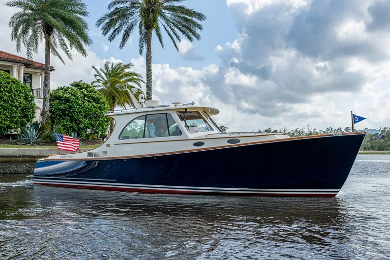 Miss Behave Yacht Photos Pics 2017 Hinckley Picnic Boat 37 MKIII cruising on a scenic waterway with palm trees.