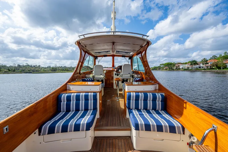 Miss Behave Yacht Photos Pics 2017 Hinckley Picnic Boat 37 MKIII with striped seating on a serene lake.