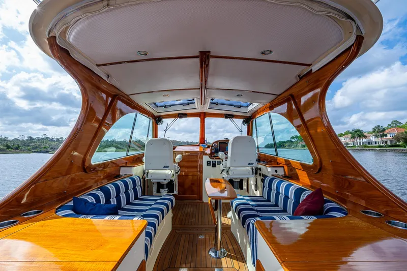 Miss Behave Yacht Photos Pics 2017 Hinckley Picnic Boat 37 MKIII interior with elegant wood finish and striped seating.