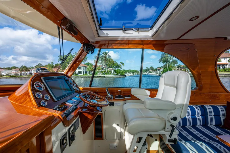Miss Behave Yacht Photos Pics Interior of 2017 Hinckley Picnic Boat 37 MKIII with luxurious helm and waterfront view.