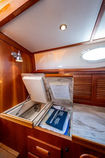 Miss Behave Yacht Photos Pics 2017 Hinckley Picnic Boat 37 MKIII interior with wooden cabinetry and storage compartment.