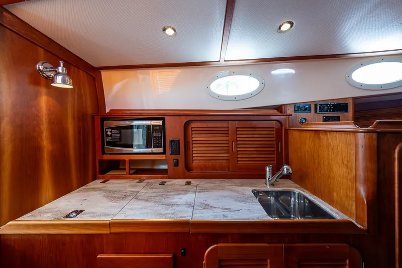 Miss Behave Yacht Photos Pics 2017 Hinckley Picnic Boat 37 MKIII galley with wood cabinetry and modern appliances.