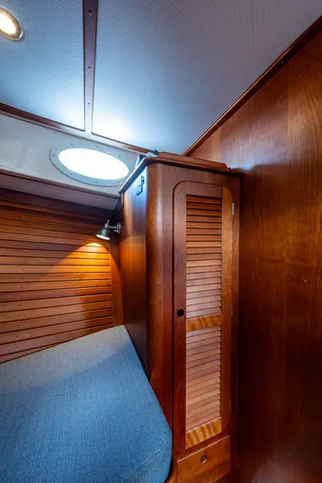 Miss Behave Yacht Photos Pics Interior cabin of 2017 Hinckley Picnic Boat 37 MKIII with wooden paneling and cozy bed.
