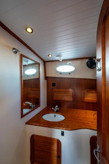 Miss Behave Yacht Photos Pics 2017 Hinckley Picnic Boat 37 MKIII bathroom with wooden cabinetry and round sink.