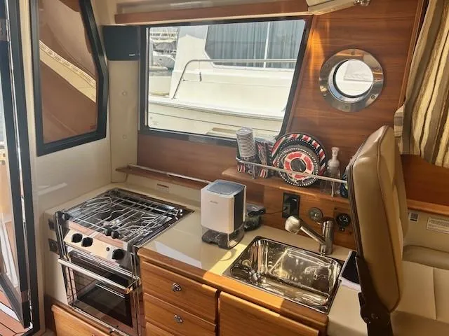  Yacht Photos Pics 2024 Ranger Luxury Edition yacht kitchen with stove, sink, and window view.