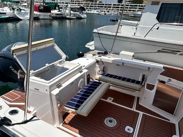 Yacht Photos Pics 2024 Ranger Luxury Edition boat with open storage, cushioned seats, docked at marina.