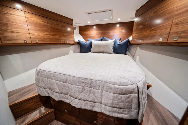 New Viking 46 Billfish Yacht Photos Pics Luxurious cabin interior of 2026 Viking 46 Billfish yacht with wood paneling and cozy bedding.
