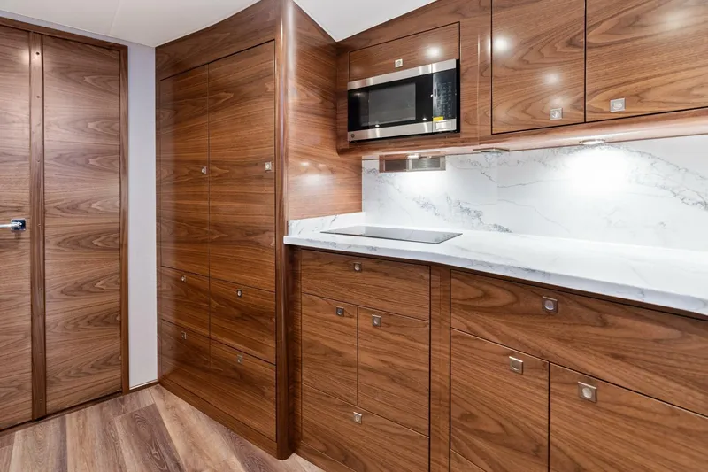 New Viking 46 Billfish Yacht Photos Pics Luxurious wood-finished kitchen interior of 2026 Viking 46 Billfish yacht with modern appliances.