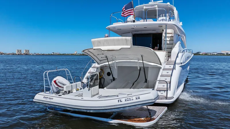  Yacht Photos Pics 2005 Lazzara 68 Pilothouse Motoryacht with tender, docked on calm water, rear view.