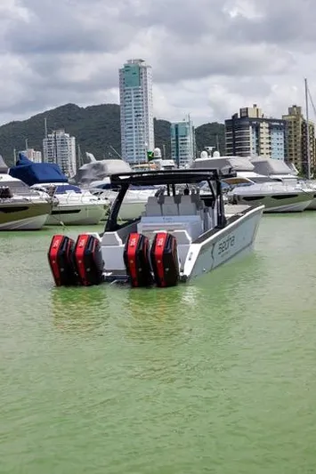  Yacht Photos Pics 2025 Sedna 420 Cat boat with triple engines docked in a marina, city skyline in background.