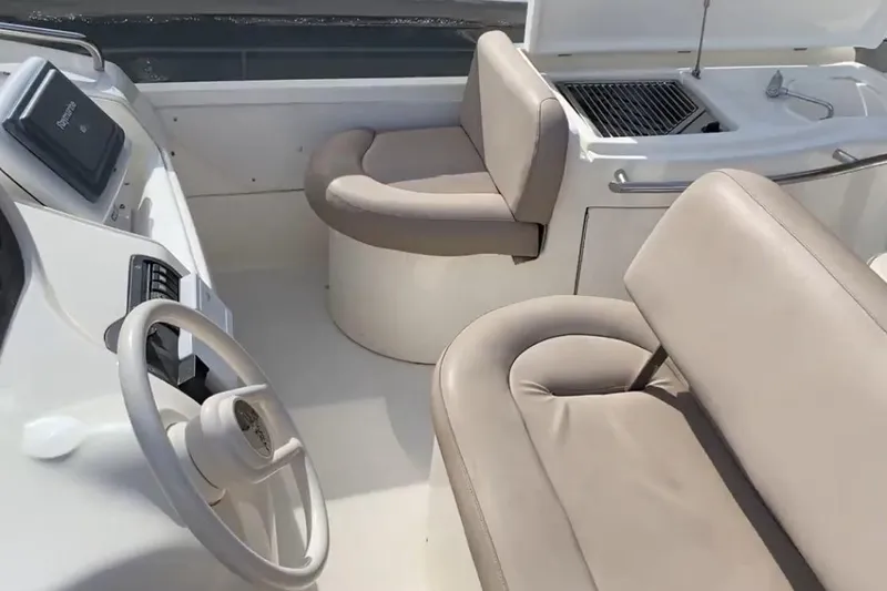 Bianca Lucida Yacht Photos Pics 1999 Azimut 58 yacht interior with beige seating and steering wheel.