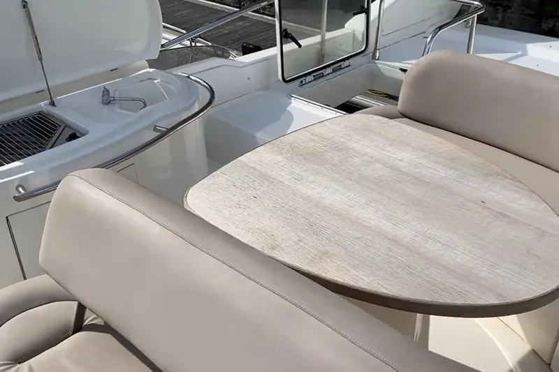 Bianca Lucida Yacht Photos Pics Luxury seating and table on 1999 Azimut 58 yacht deck, featuring sleek design and comfort.