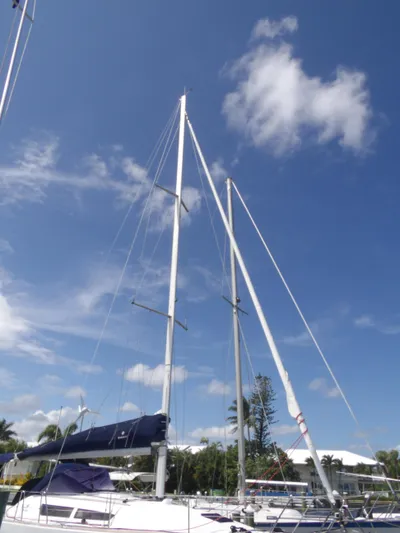 Magic Carpet Yacht Photos Pics Sailboat Jeanneau Sun Odyssey 36i, 2010 model, with tall masts against a clear blue sky.