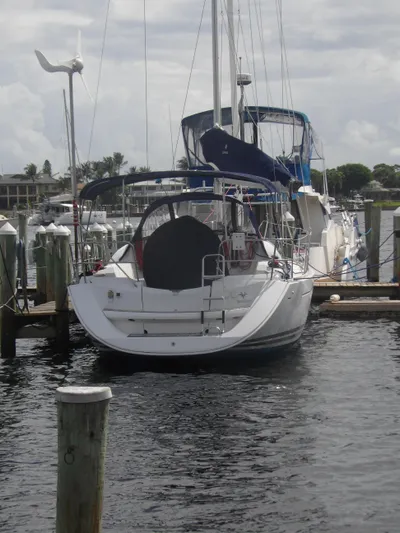 Magic Carpet Yacht Photos Pics 2010 Jeanneau Sun Odyssey 36i sailboat docked at marina, calm water, overcast sky.