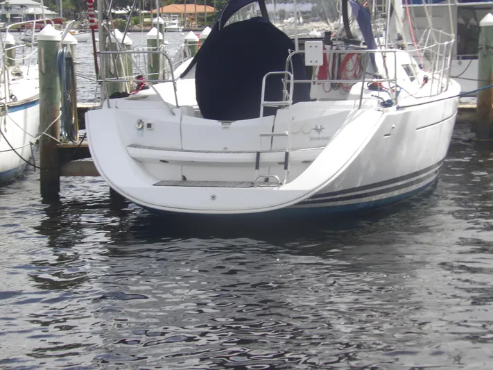 Magic Carpet Yacht Photos Pics Jeanneau Sun Odyssey 36i sailboat docked, 2010 model, rear view with calm water.