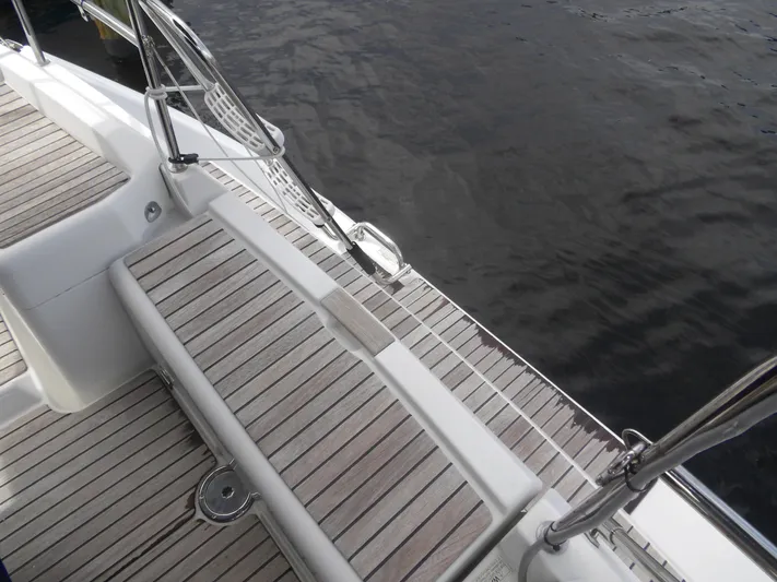 Magic Carpet Yacht Photos Pics Jeanneau Sun Odyssey 36i 2010 yacht deck with wooden finish by the water.