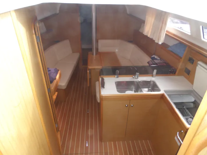 Magic Carpet Yacht Photos Pics Interior of 2010 Jeanneau Sun Odyssey 36i sailboat with wood finish and compact kitchen.