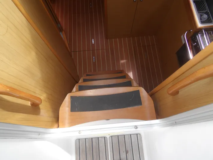Magic Carpet Yacht Photos Pics Staircase leading to cabin interior of 2010 Jeanneau Sun Odyssey 36i sailboat.