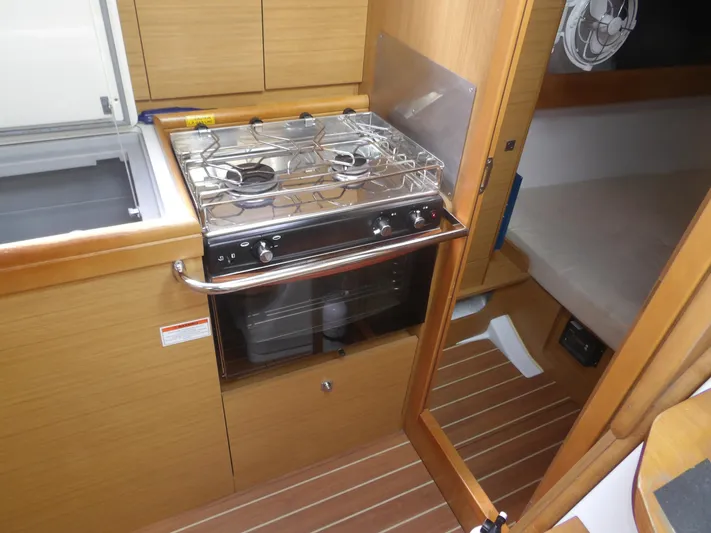 Magic Carpet Yacht Photos Pics Jeanneau Sun Odyssey 36i 2010 yacht interior with compact kitchen and stove.