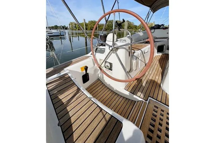 Rising Sun Yacht Photos Pics 2016 Jeanneau Sun Odyssey 50 DS sailboat cockpit with wooden deck and steering wheel.