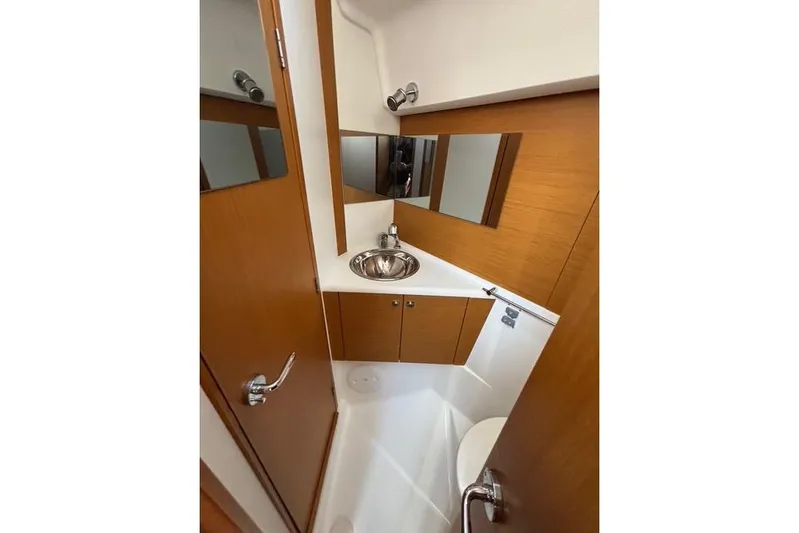 Rising Sun Yacht Photos Pics 2016 Jeanneau Sun Odyssey 50 DS bathroom with wooden cabinetry and stainless steel sink.