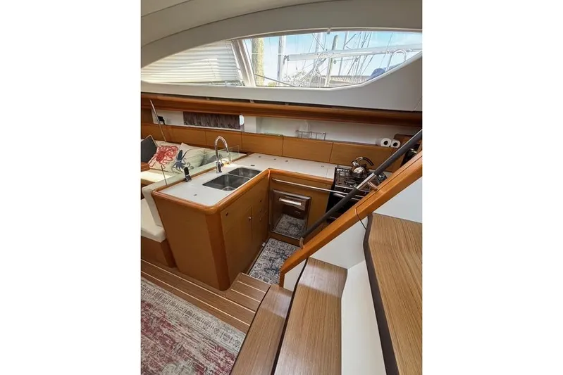 Rising Sun Yacht Photos Pics Interior of 2016 Jeanneau Sun Odyssey 50 DS yacht, featuring modern kitchen and wooden stairs.