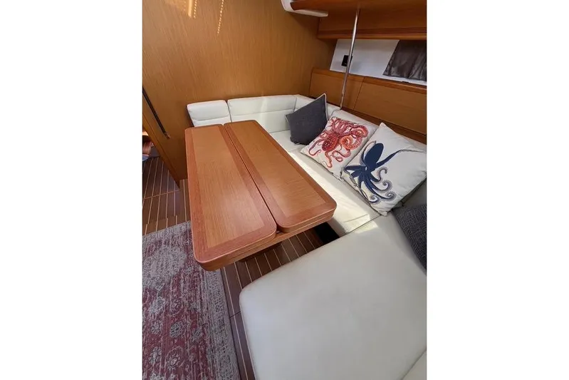 Rising Sun Yacht Photos Pics Interior of 2016 Jeanneau Sun Odyssey 50 DS with cozy seating and nautical-themed pillows.