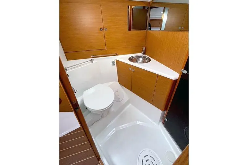 Rising Sun Yacht Photos Pics Bathroom interior of 2016 Jeanneau Sun Odyssey 50 DS yacht, featuring wood cabinetry and modern fixtures.