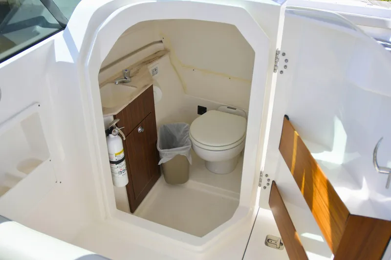  Yacht Photos Pics 2024 Pursuit DC 246 Dual Console boat interior with toilet and sink.