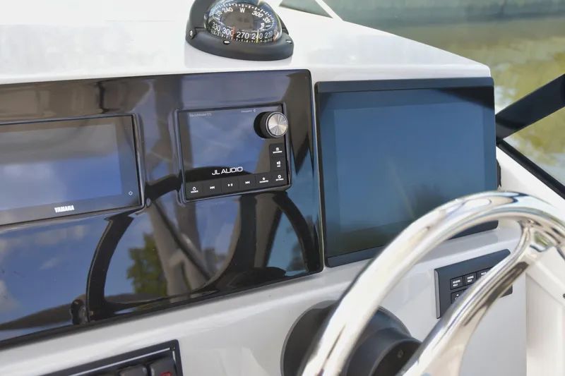  Yacht Photos Pics 2024 Pursuit DC 246 Dual Console dashboard with compass, audio system, and steering wheel.