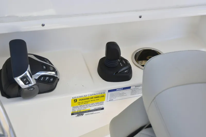  Yacht Photos Pics 2024 Pursuit DC 246 Dual Console boat controls and capacity label, seating visible.