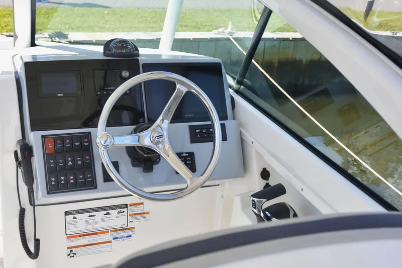  Yacht Photos Pics 2024 Pursuit DC 246 Dual Console boat dashboard with steering wheel and controls.