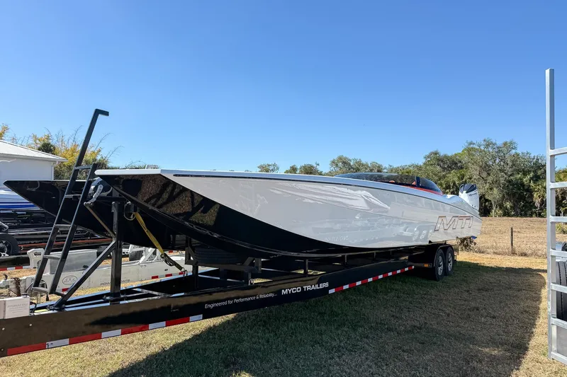  Yacht Photos Pics 2021 MTI 390X powerboat on trailer, sleek design, outdoors under clear blue sky.