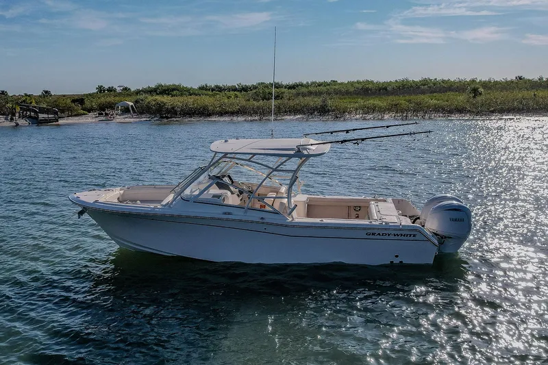 Fin & Tonic Yacht Photos Pics 2024 Grady-White Freedom 275 boat on water, sunny day, near shoreline.