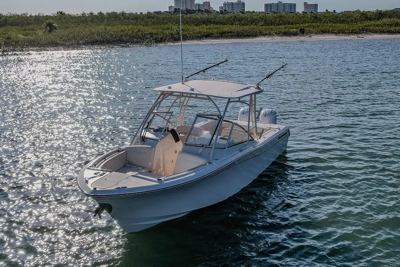 Fin & Tonic Yacht Photos Pics 2024 Grady-White Freedom 275 boat on sparkling water near shoreline.