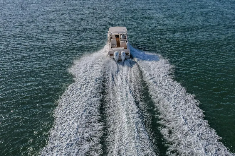 Fin & Tonic Yacht Photos Pics 2024 Grady-White Freedom 275 boat cruising on open water, leaving a wake.