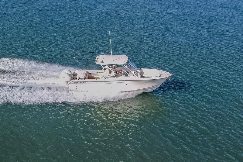 Fin & Tonic Yacht Photos Pics 2024 Grady-White Freedom 275 boat cruising on clear blue water.