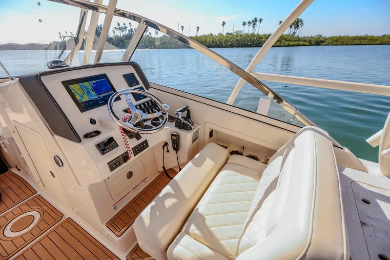 Fin & Tonic Yacht Photos Pics 2024 Grady-White Freedom 275 boat interior with steering wheel and navigation system.