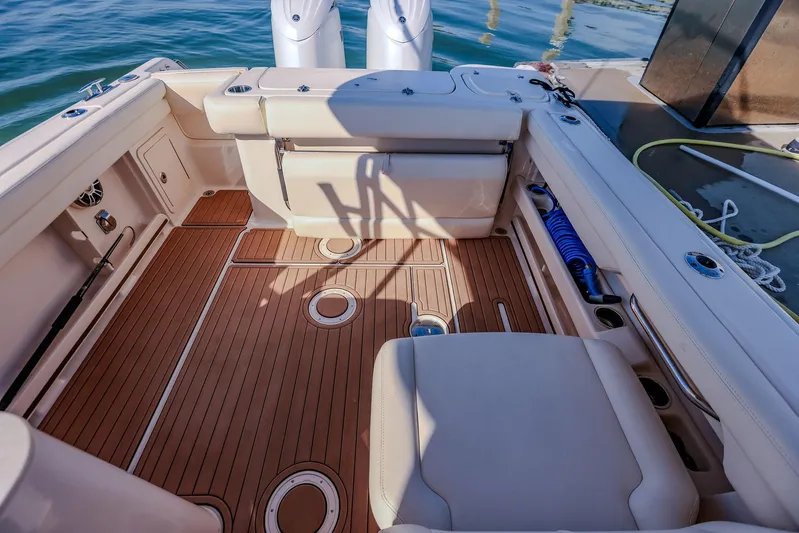 Fin & Tonic Yacht Photos Pics 2024 Grady-White Freedom 275 boat interior with teak flooring and seating.
