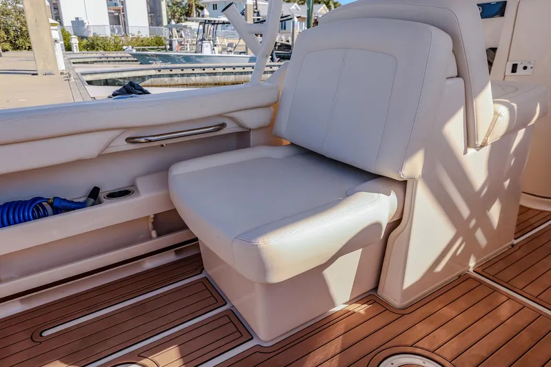 Fin & Tonic Yacht Photos Pics 2024 Grady-White Freedom 275 boat interior with cushioned seating and wooden deck.